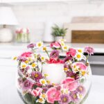 This DIY Flower Garden Candle Vase is filled with bright pink and purple flowers with a flameless candle in the center.